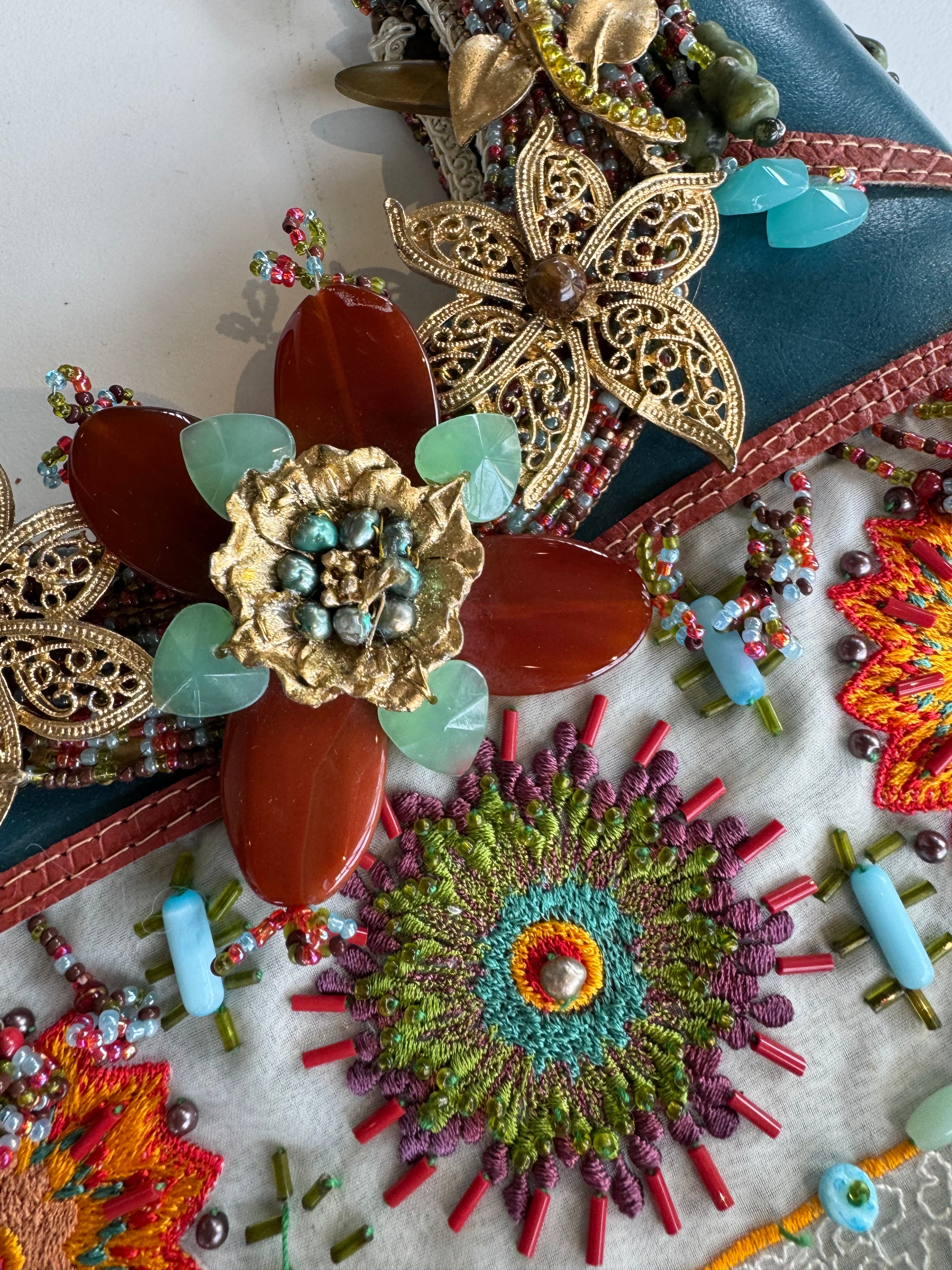 Close-up of decorative brooches with floral designs on a textured surface.